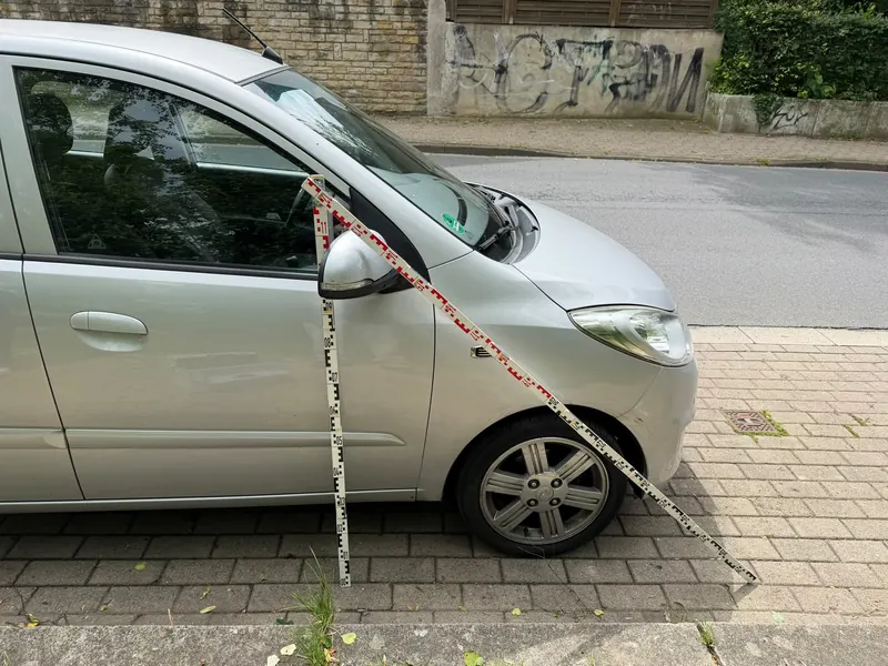 Hyundai i10 mit kleiner Delle am vorderen Kotflügel, Kennzeichen unkenntlich gemacht. Das Kfz-Gutachten ergab 3.800 € Schaden.