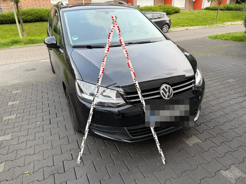 VW Sharan mit Kratzern an der Front, Kennzeichen unkenntlich gemacht. Das Kfz-Gutachten ergab 2.700 € Schaden.